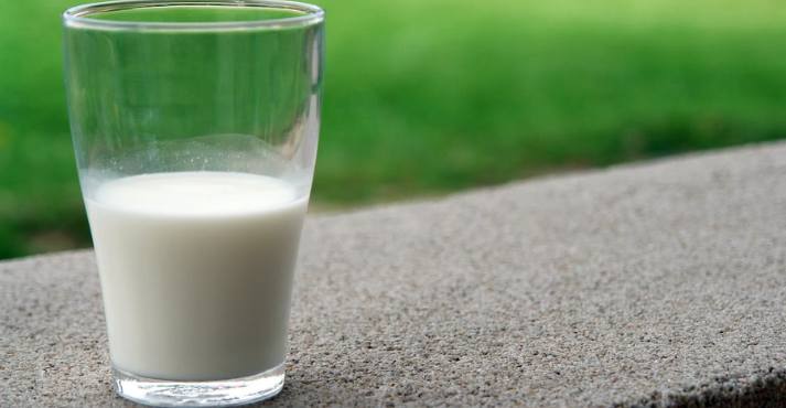 glass of milk placed on a concrete surface