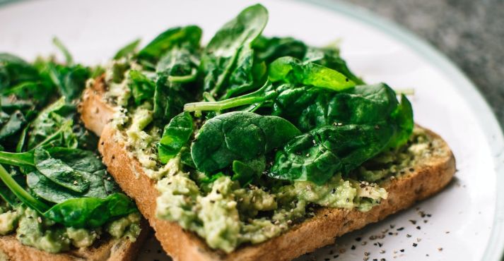 vegan food basil leaves and avocado on bread