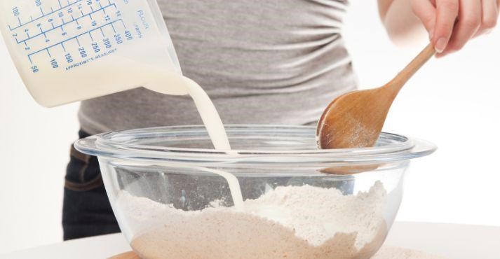 Pouring-buttermilk-in-flour-for-baking